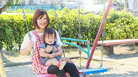 ブランコに乗る園児と保育士