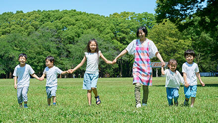 子どもたちと手をつなぐ保育士