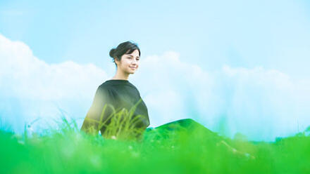 草原でくつろぐ女性