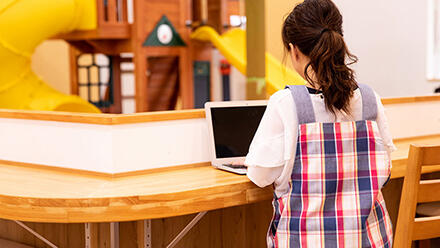 パソコンで作業する保育士