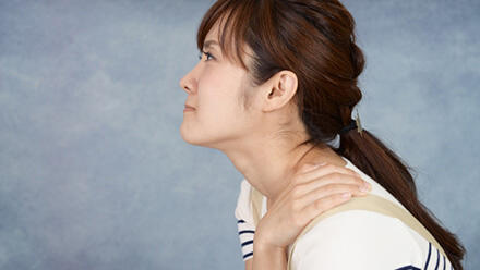 肩を押さえる女性