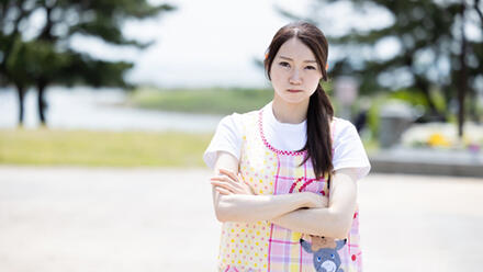 腕組みをする保育士