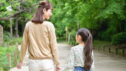 手をつないで歩く女性と子ども