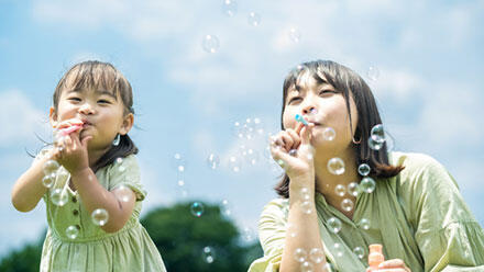 シャボン玉で遊ぶ女性と子ども