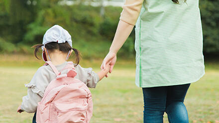 保育士と手をつなぐ子ども
