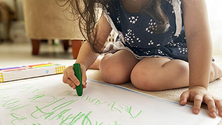 クレヨンでお絵かきをする子ども