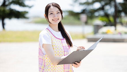 ファイルを手に微笑む保育士